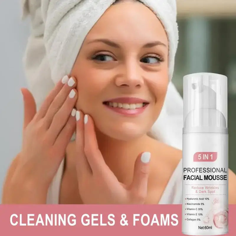 Smiling woman with a white towel on her head, touching her face next to a facial mousse product.