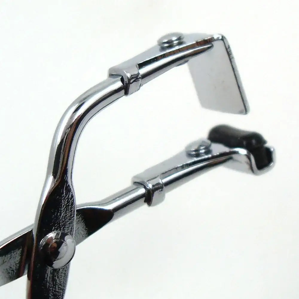 Eyelash curler with chrome-plated metal construction and black rubber pads.