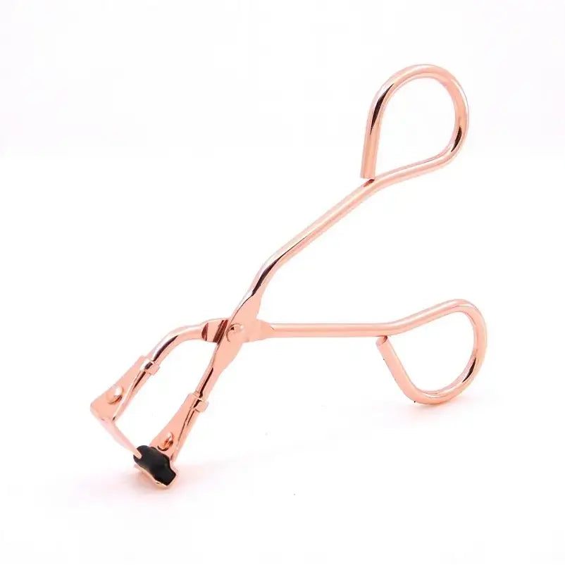 Rose gold eyelash curler with curved handles and a silicone pad.