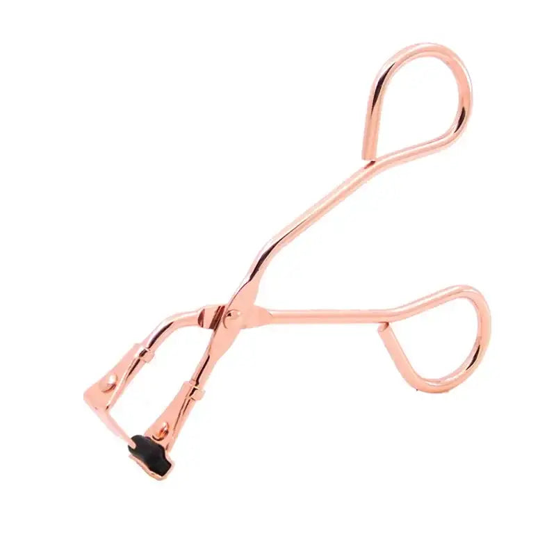 Rose gold eyelash curler with curved handles and a silicone pad.