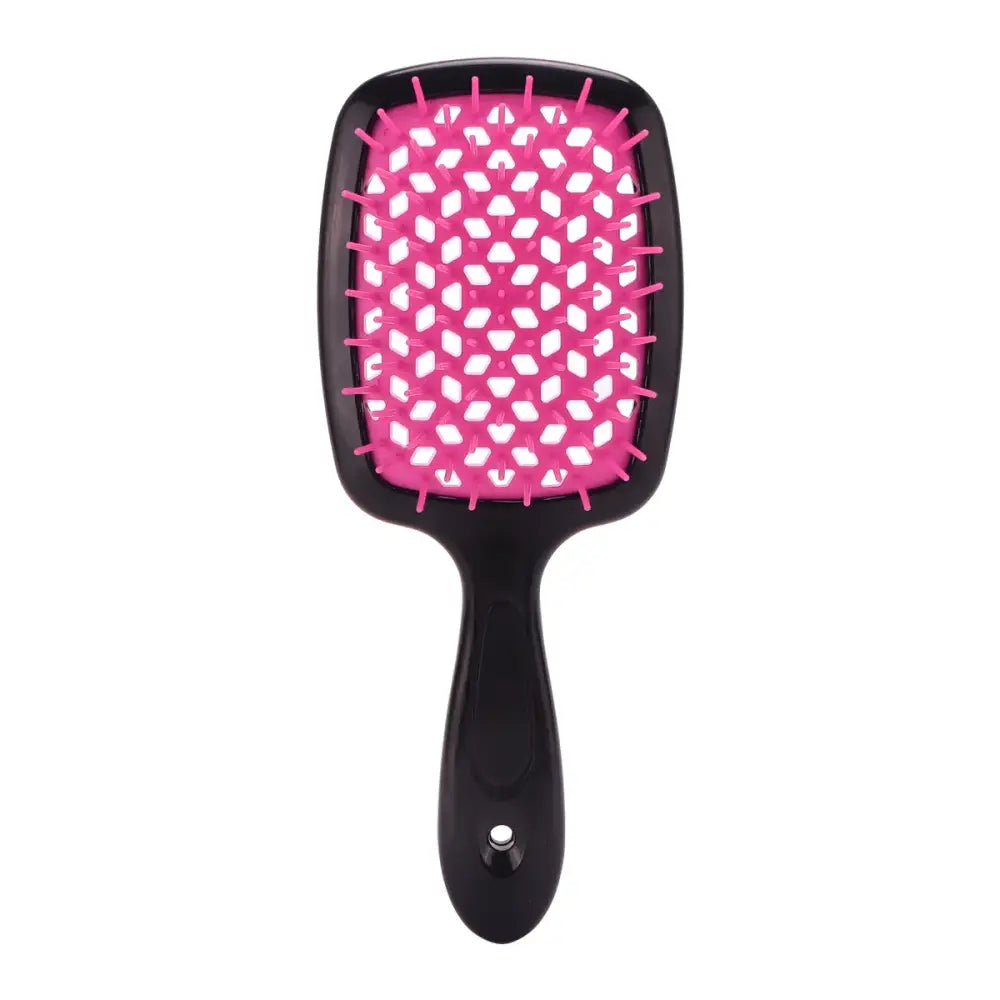 Pink and black paddle hairbrush with heart-shaped pattern on the bristle surface.