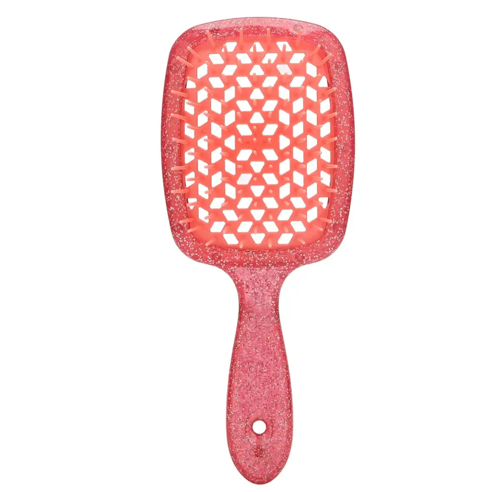 Pink paddle hairbrush with a geometric pattern on its cushion.