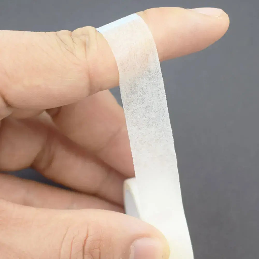 White adhesive bandage or medical tape wrapped around a finger.