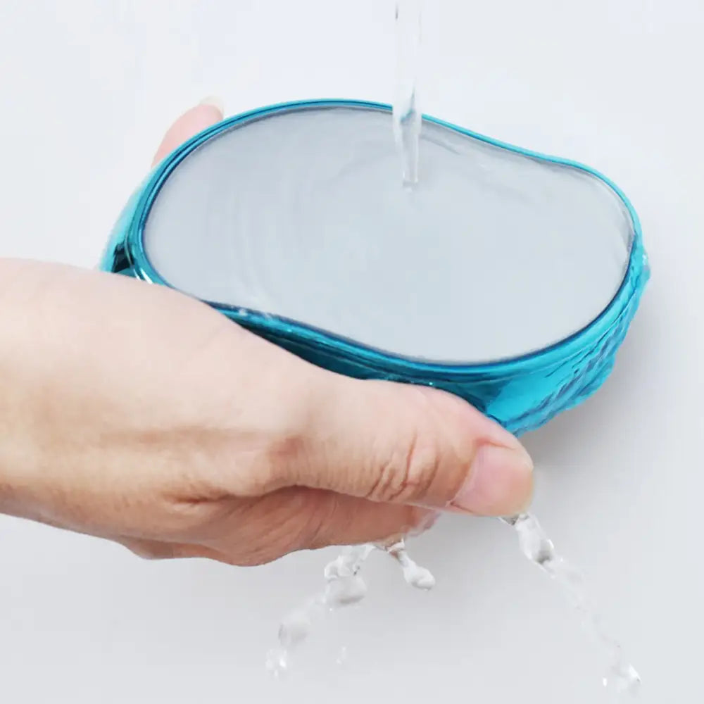 Teal silicone or rubber strainer being squeezed by a hand.