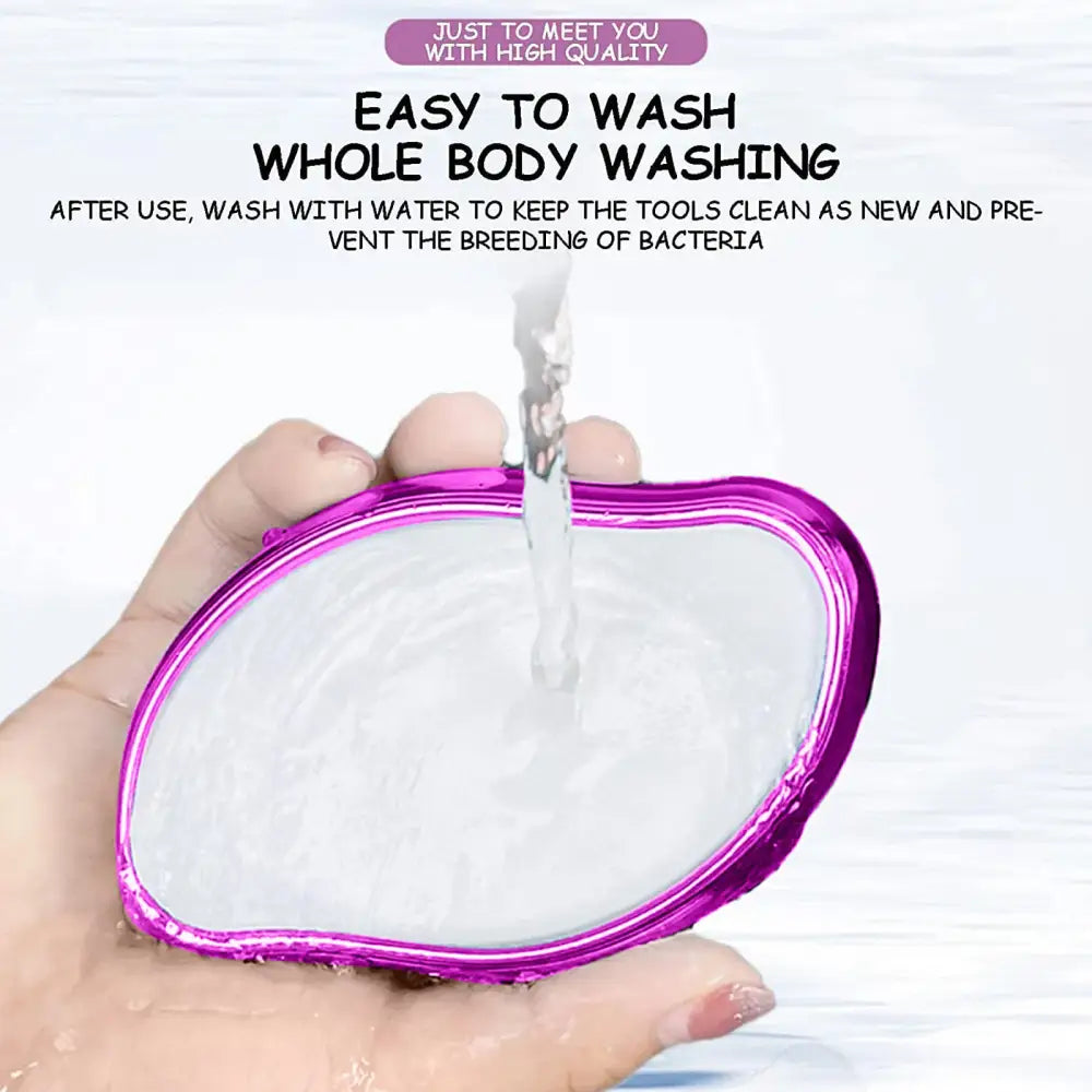 Transparent silicone body scrubber with a purple border being rinsed under running water.