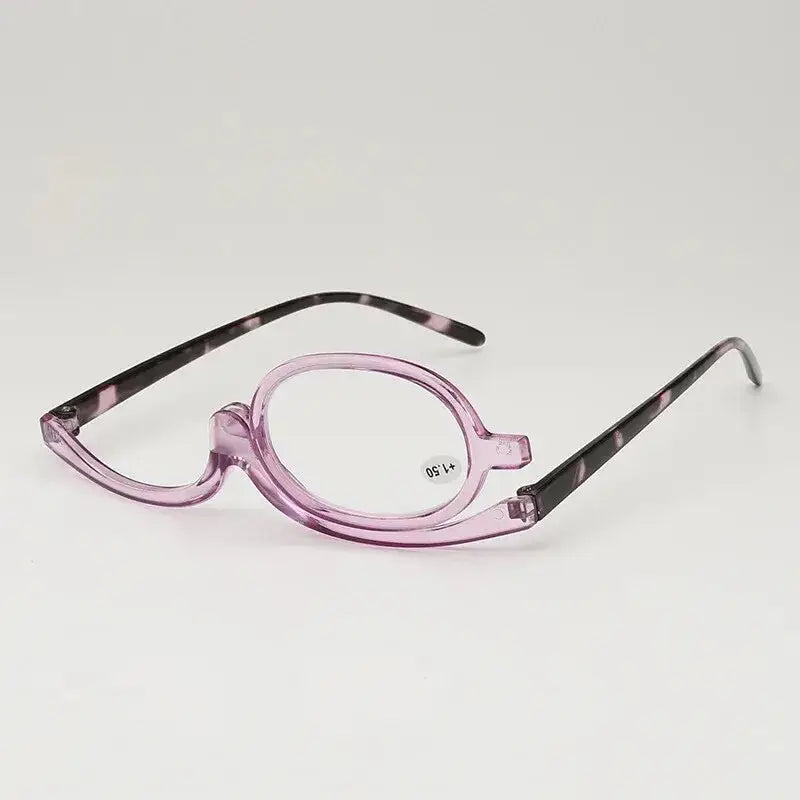 Pink-framed makeup application glasses with one magnifying lens.