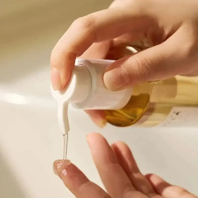 Bottle of nail polish with brush applicator being used to apply polish to a fingernail.