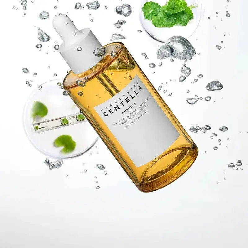 Bottle of Centella skincare product surrounded by water droplets and green leaves.