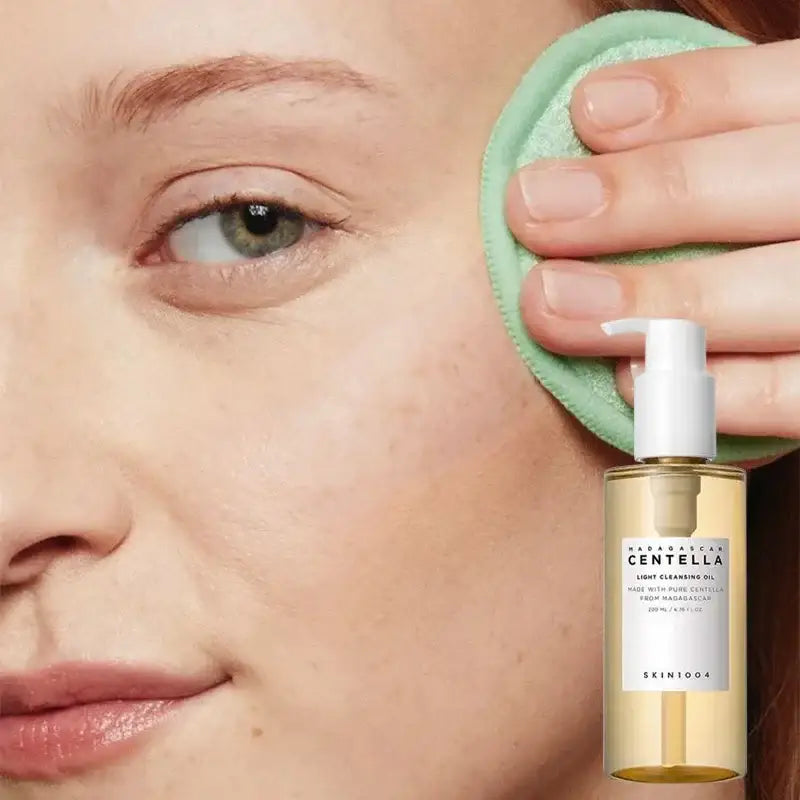 Bottle of Centella skincare product held next to a person’s face with a green application pad.