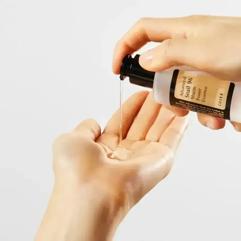 Bottle of serum or oil being dispensed onto a hand.