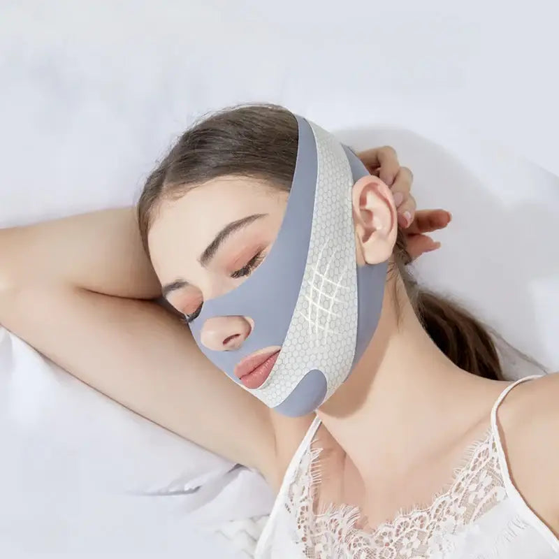 Facial mask or beauty treatment device worn by a person with closed eyes.