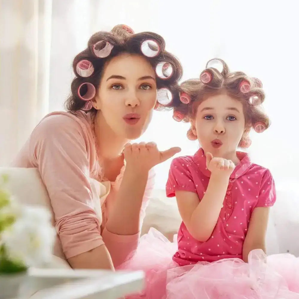 Two people with hair rollers blowing kisses at the camera.