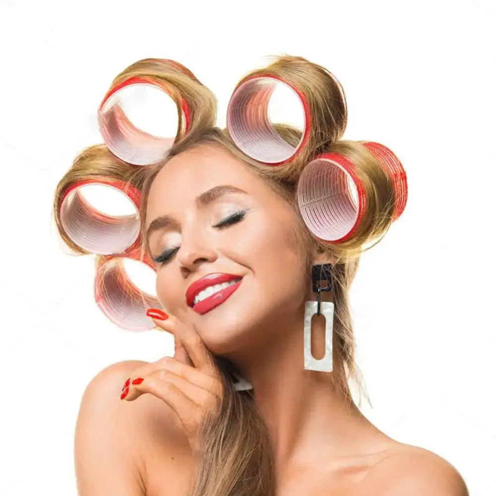 Woman with hair rollers and bright red lipstick smiling with eyes closed.