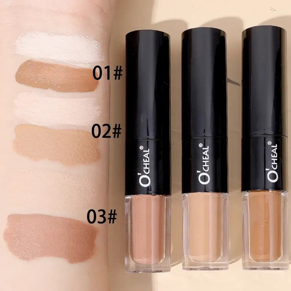 Three black tubes of liquid concealer or foundation with swatches of different skin tone shades next to them.