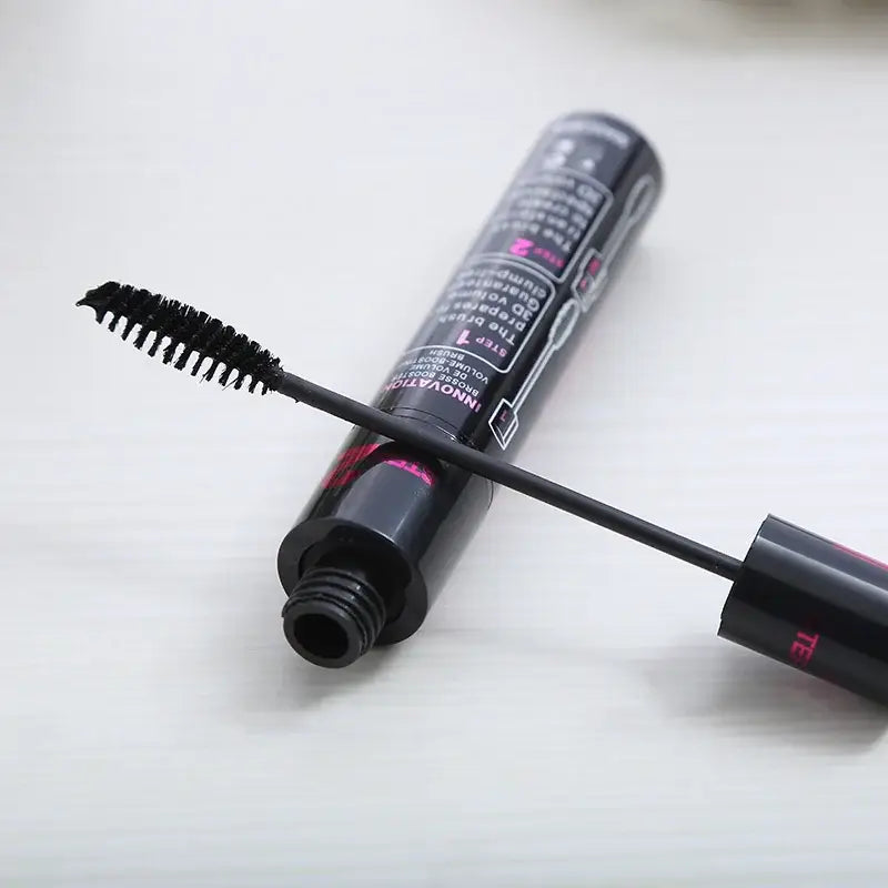 Mascara tube with an open wand applicator displaying the brush bristles.