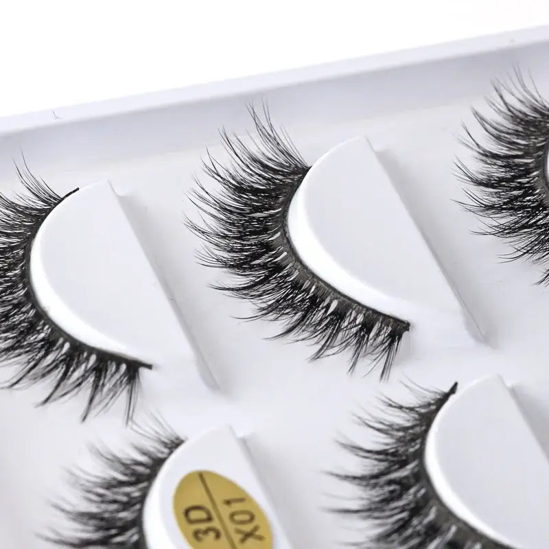 False eyelashes arranged on a white surface.