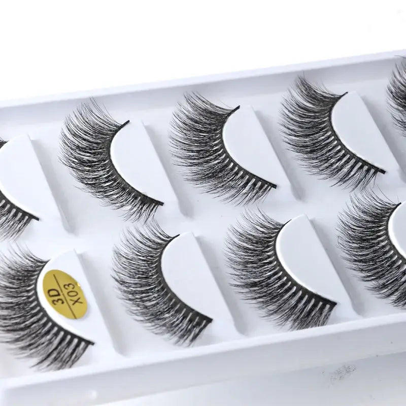 Set of false eyelashes arranged in a white plastic tray.