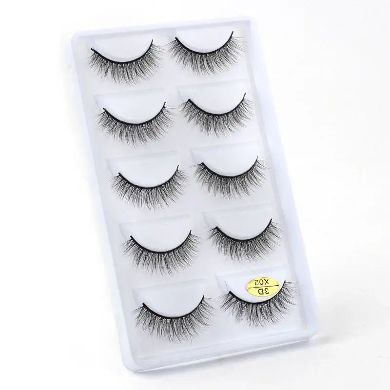 Set of five pairs of false eyelashes arranged on a white display card.