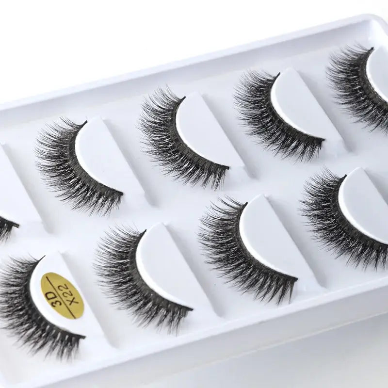 Set of five pairs of false eyelashes in a white plastic tray.