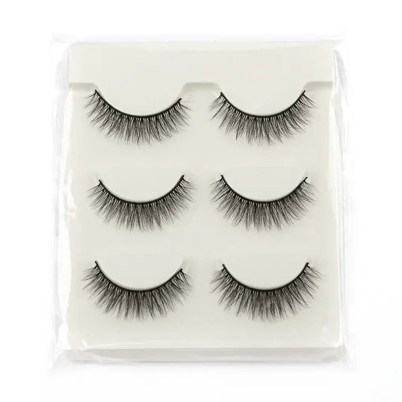 Set of three pairs of false eyelashes arranged on a white background.