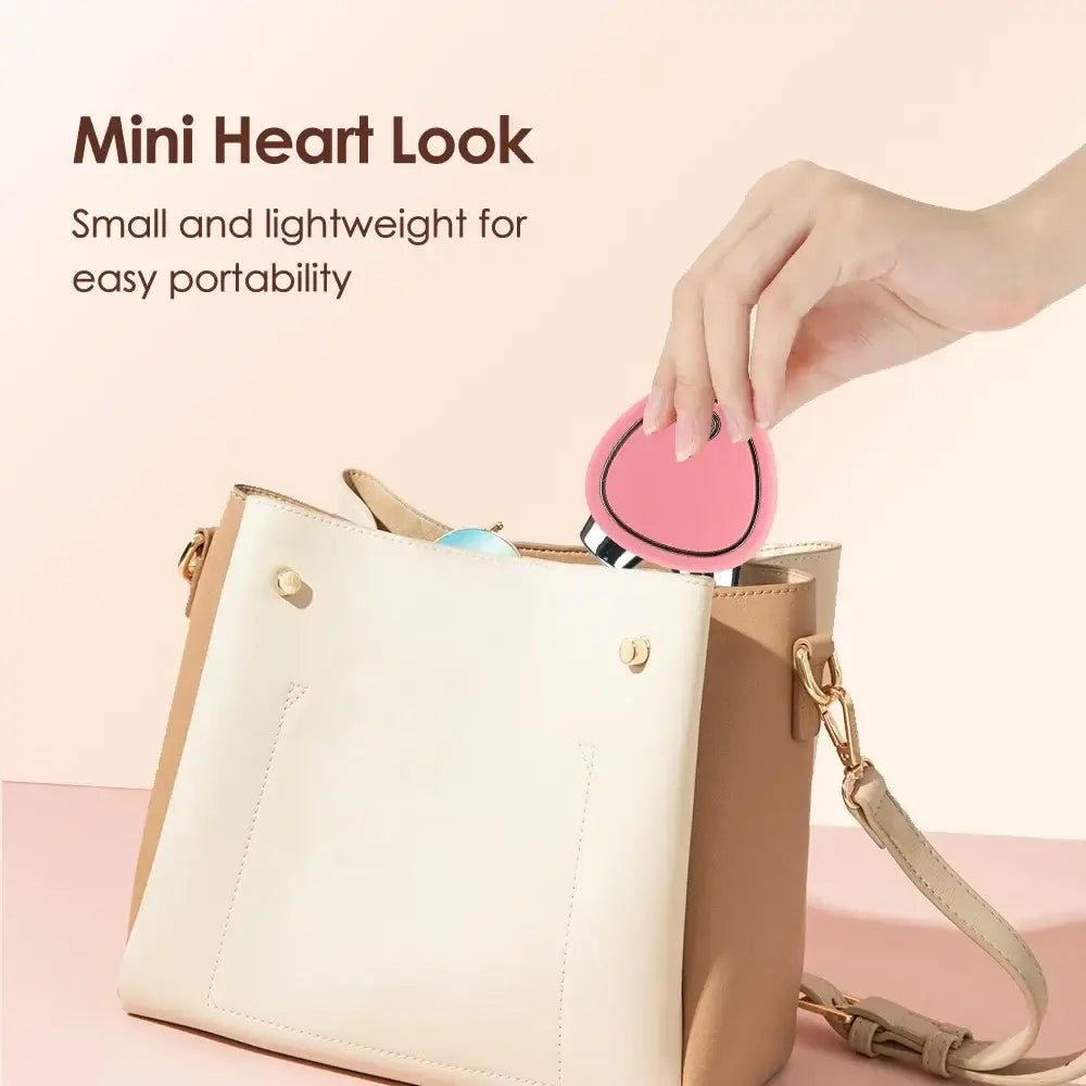 Cream-colored handbag with a detachable pink heart-shaped accessory.