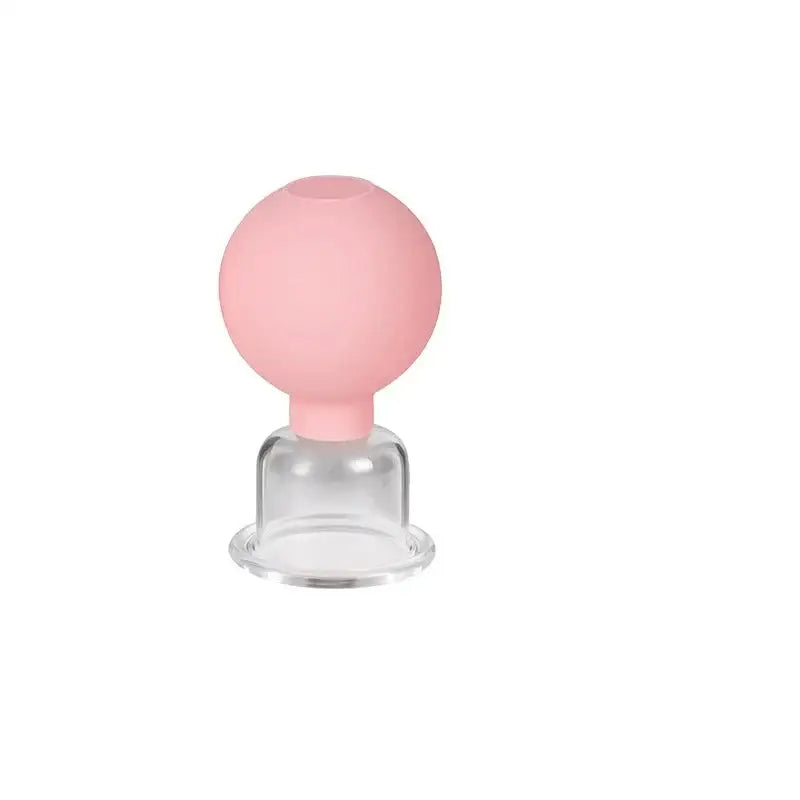 Glass cupping jar with a pink rubber bulb on top.