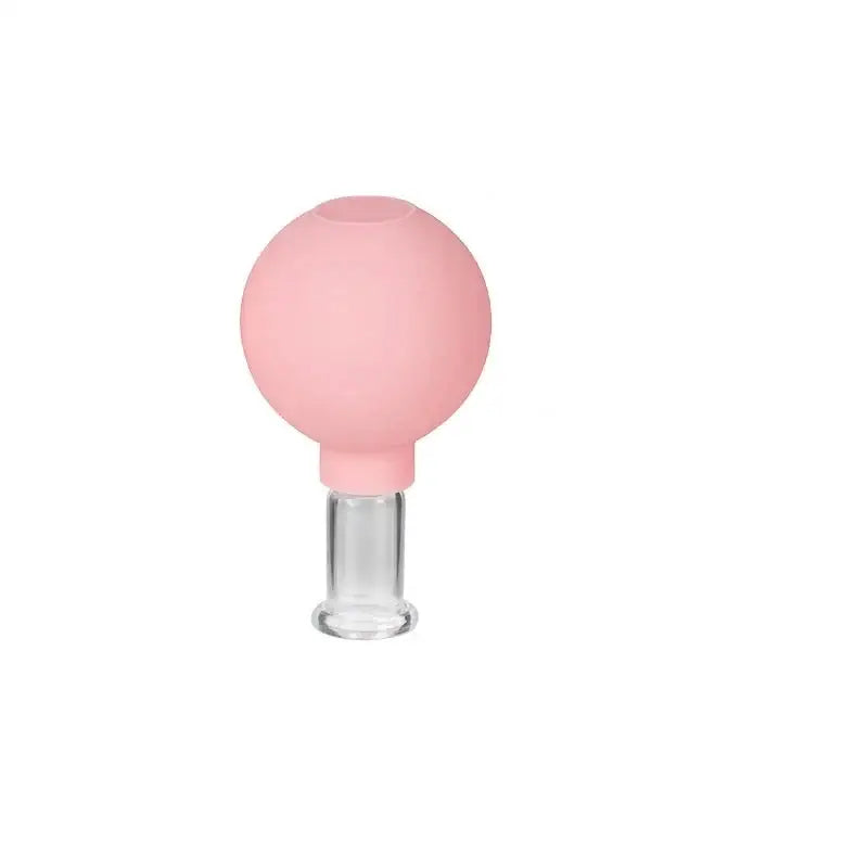 Pink spherical glass object atop a clear cylindrical base.