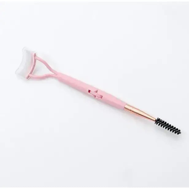 Pink facial roller with a brush on one end.