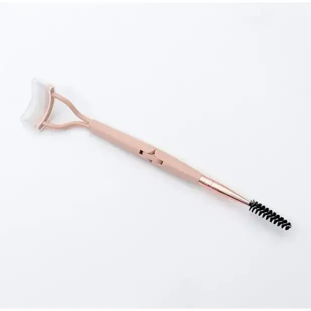 Pink facial roller with a brush on one end and a textured roller on the other.