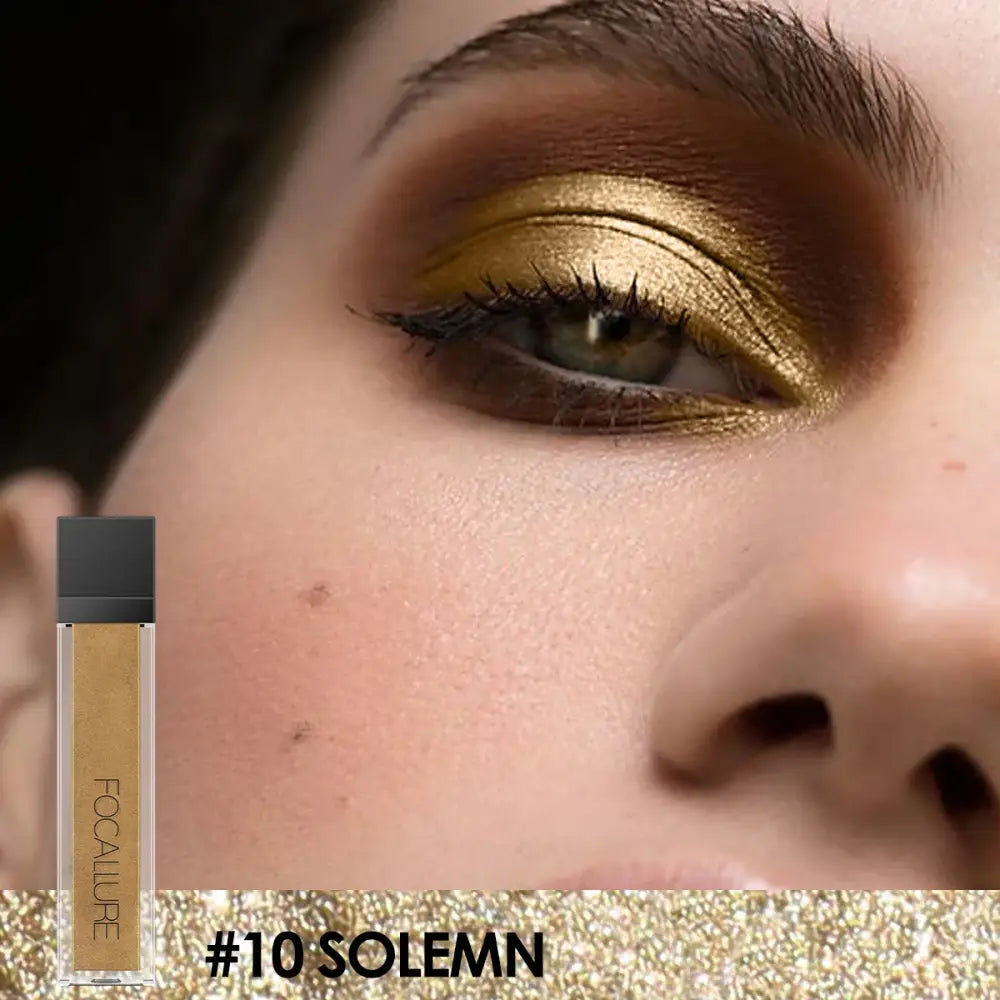 Close-up of an eye with shimmering gold eyeshadow and dramatic makeup.