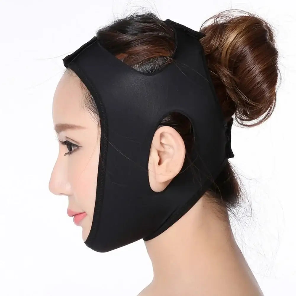 Black face-slimming mask or chin strap worn on a person’s head.