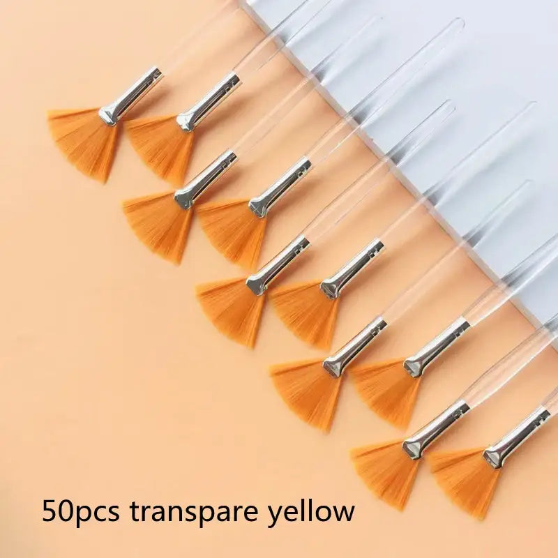 Fan-shaped nail art brushes with transparent yellow bristles and metal handles.