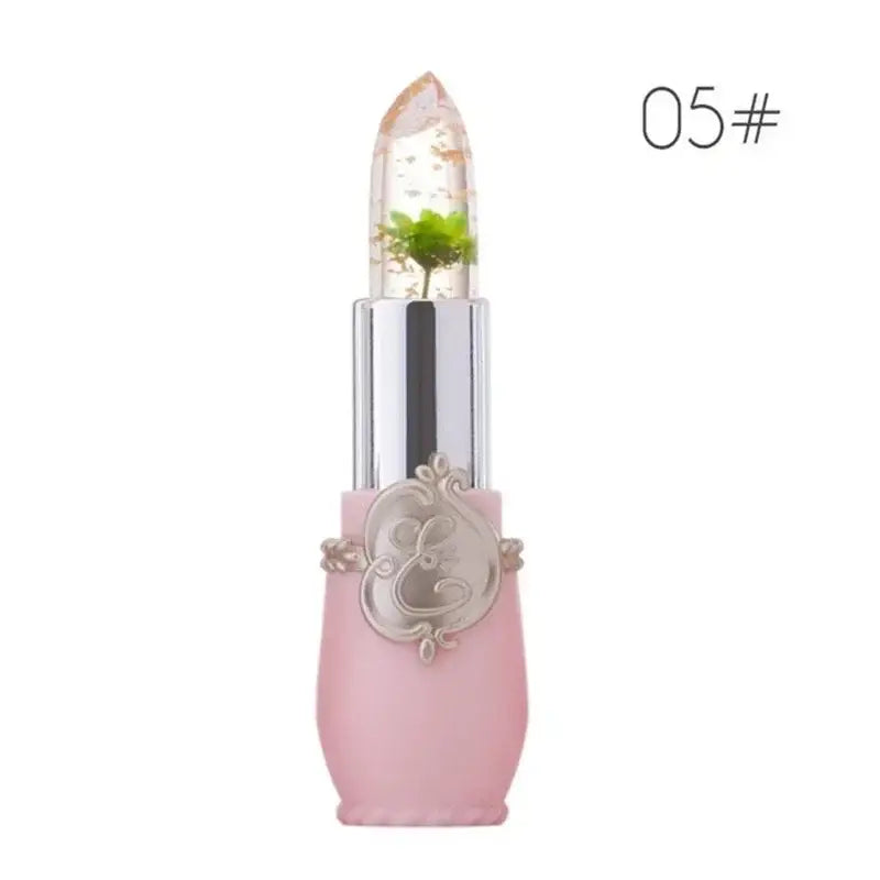 Pink lipstick tube with a clear cap containing a small plant.