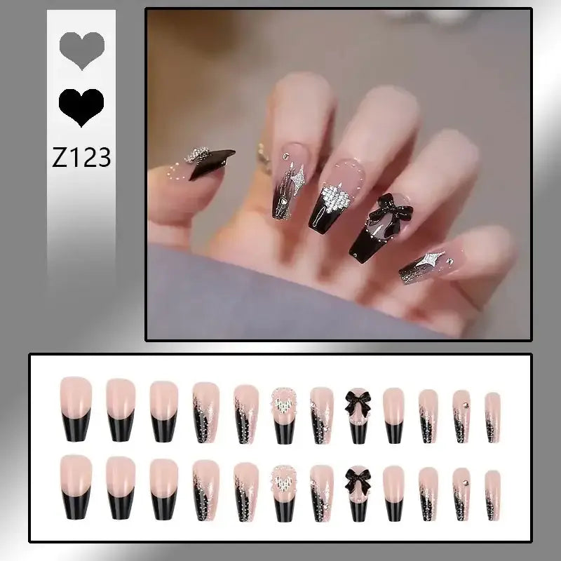 Elaborately decorated acrylic nails featuring black tips, glitter, and bow designs.