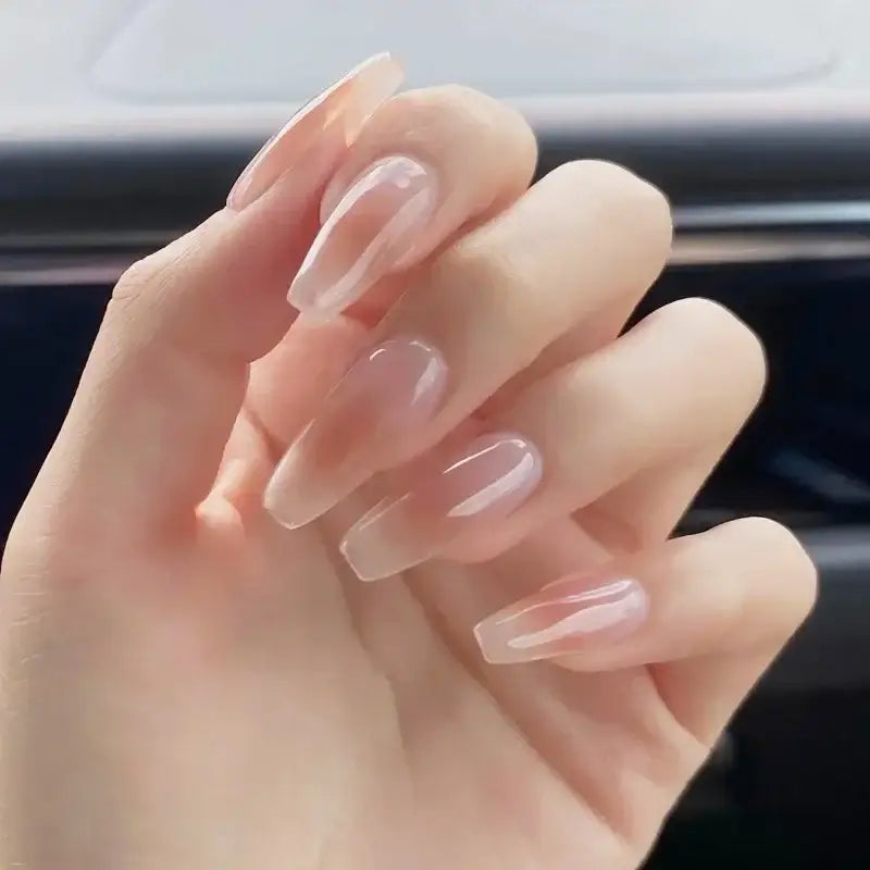 Hand with long, glossy acrylic nails in a neutral pink shade.