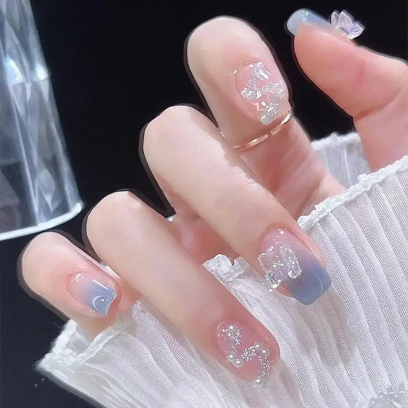 Manicured fingernails with pastel blue and clear nail art designs.