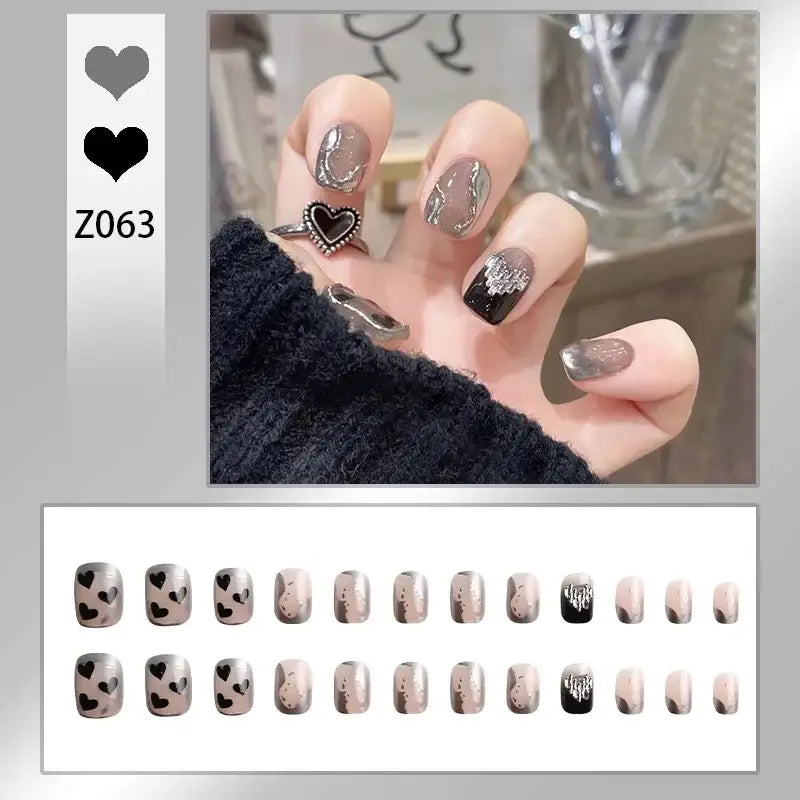 Manicured nails with a heart-themed design in gray, black, and glitter.