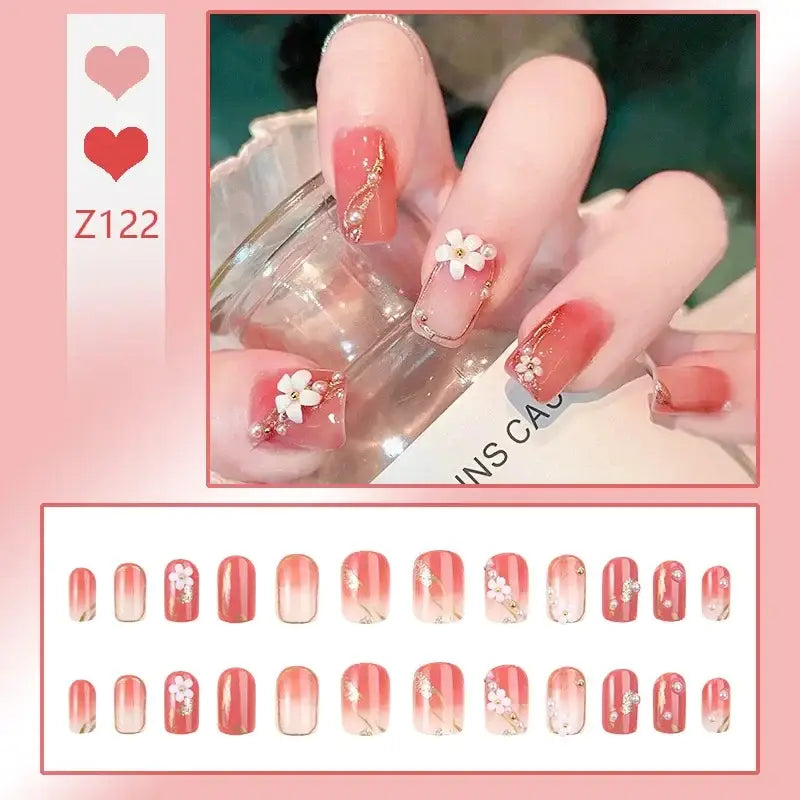 Manicured nails with floral and gradient designs in pink and white tones.