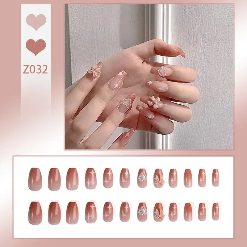 Manicured hand with long, pink-toned nails featuring delicate floral designs.