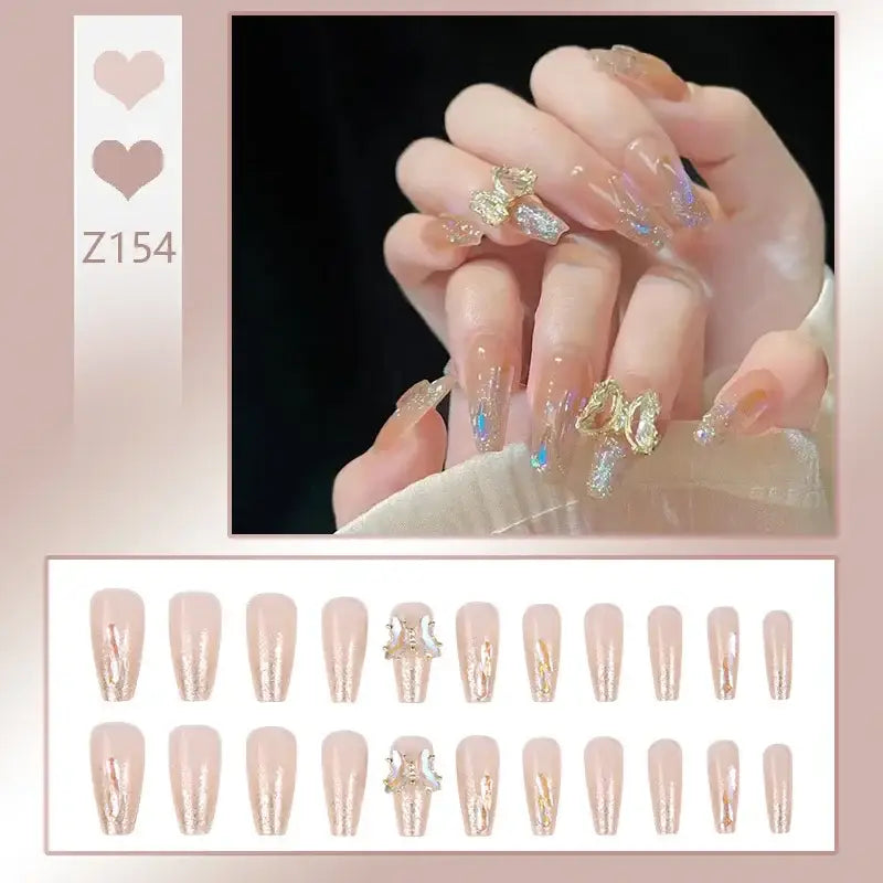 Manicured hand with elaborately decorated nails featuring gold and iridescent accents.