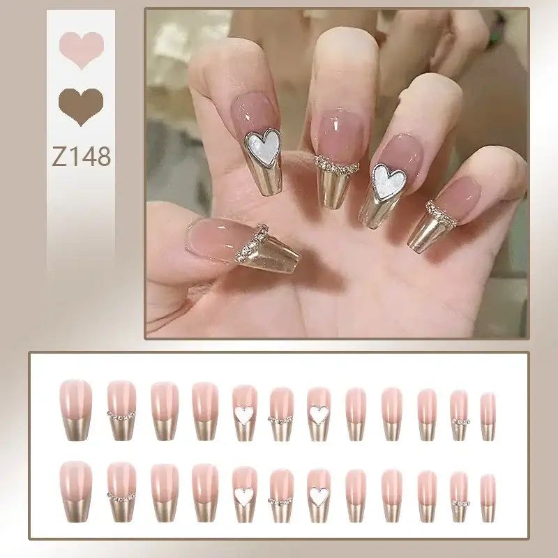 Manicured nails with heart designs and metallic tips.