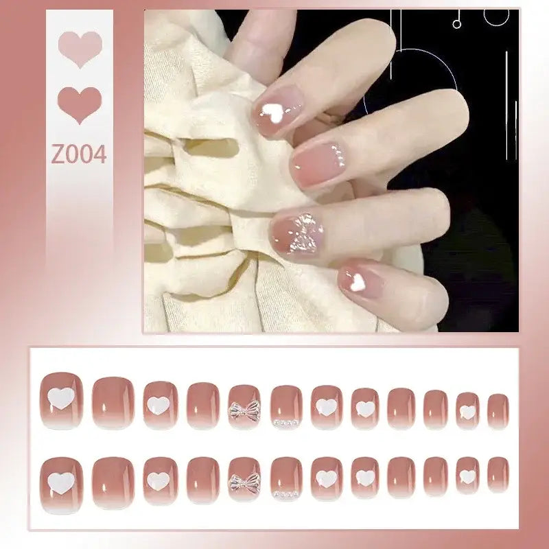 Manicured nails with pink and white heart designs.