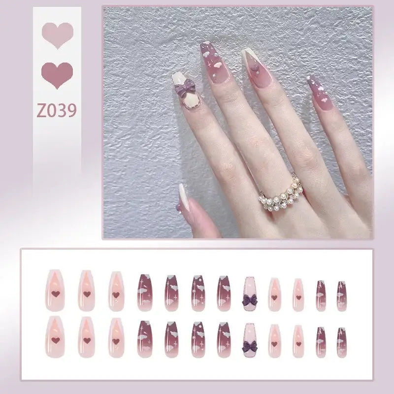 Manicured nails with pink and white designs, flowers, and pearls.