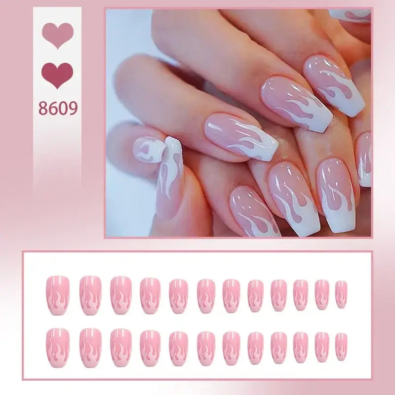 Manicured nails with a white flame or swirl design on a pale pink base.