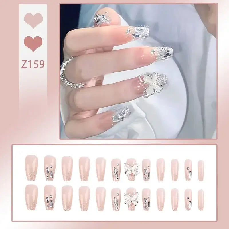 Set of artificial nails with pale pink base color and silver floral accents.