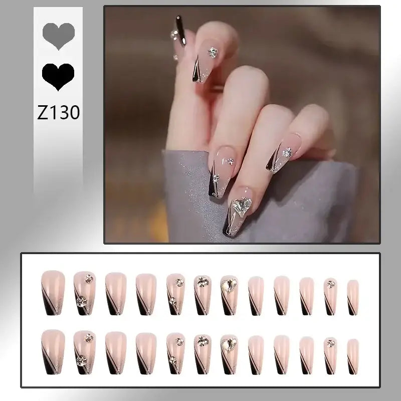 Stylized fingernails with intricate black and gold designs on a pale pink base.