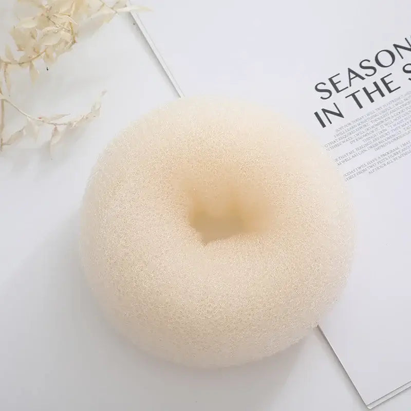 White, ring-shaped sponge or foam object with a smooth texture.