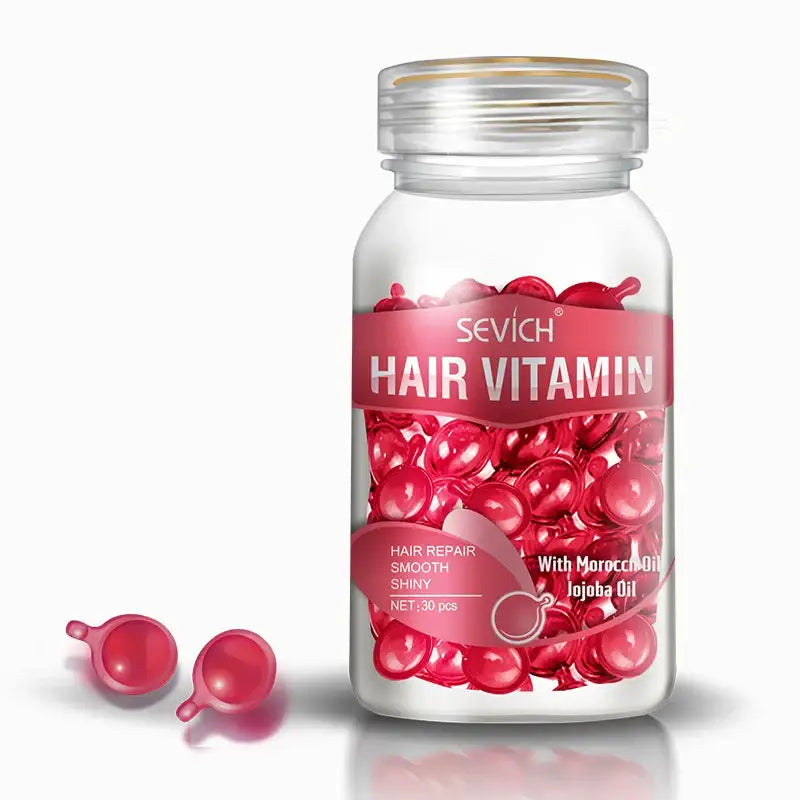 Clear bottle filled with red, spherical hair vitamin capsules.