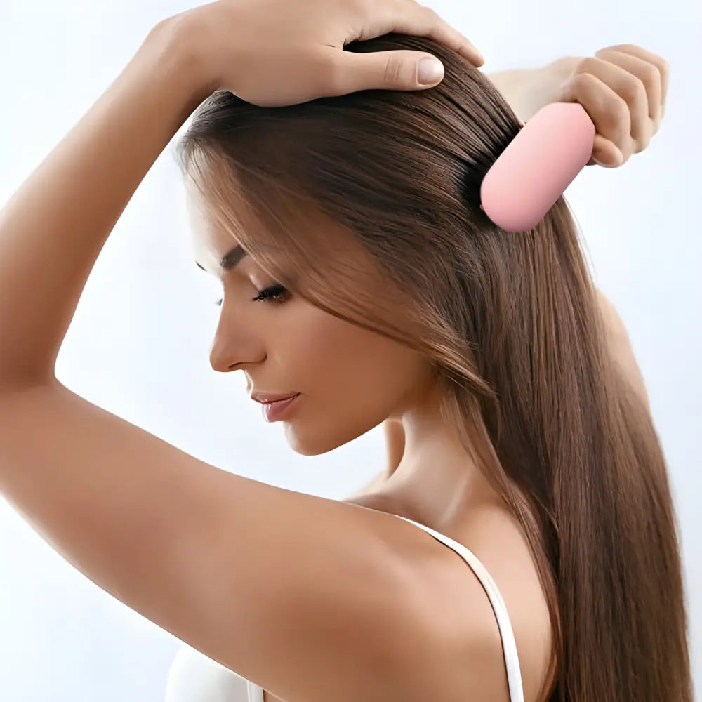 Woman brushing her long brown hair with a pink hairbrush.