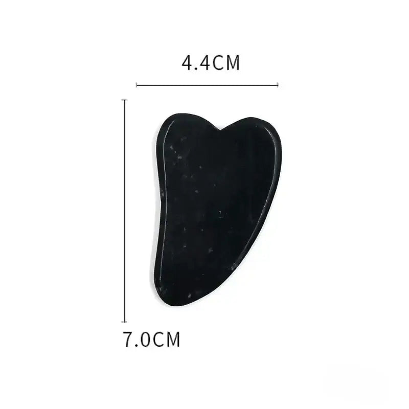 Black heart-shaped gua sha tool with measurements indicated.